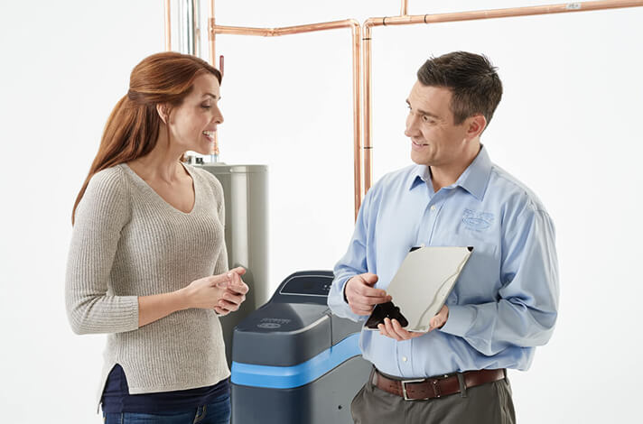 An Ecowater dealer speaking with a woman.